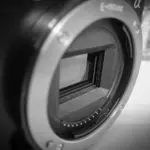 Nahaufnahme einer Digitalkamera mit Objektivfassung und belichtetem Bildsensor in Schwarz-Weiß.