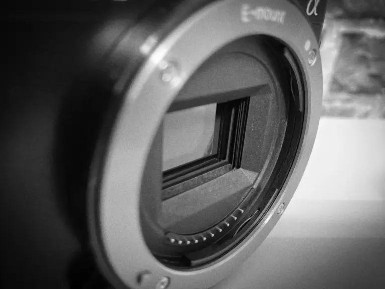 Nahaufnahme einer Digitalkamera mit Objektivfassung und belichtetem Bildsensor in Schwarz-Weiß.