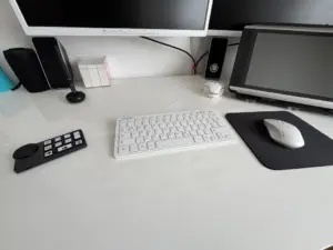 Ein weißer Schreibtisch mit Tastatur und Maus. Daneben liegt die kleine, kompakte Zusatztastatur XPen