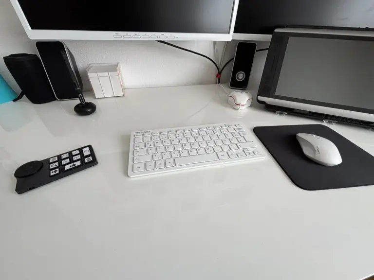 Ein weißer Schreibtisch mit Tastatur und Maus. Daneben liegt die kleine, kompakte Zusatztastatur XPen